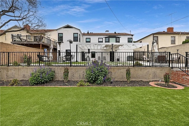 rear view of house with a lawn, a fenced backyard, and stucco siding