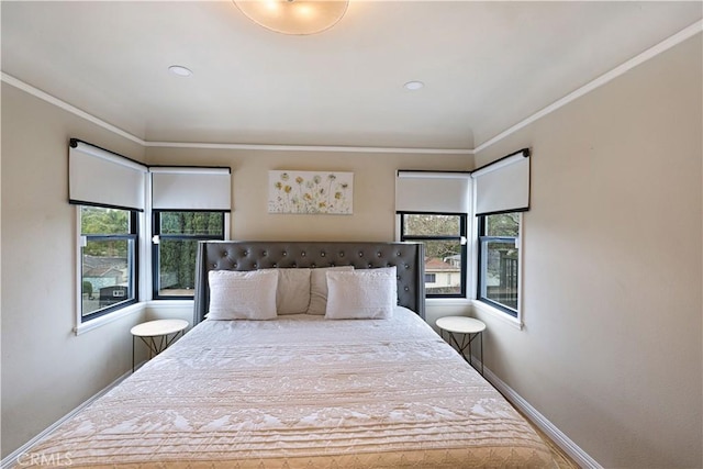 bedroom with baseboards, ornamental molding, and multiple windows