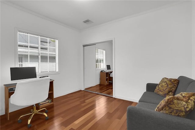 office featuring crown molding, baseboards, visible vents, and wood finished floors