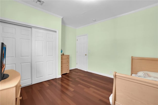 bedroom featuring dark wood finished floors, baseboards, visible vents, ornamental molding, and a closet