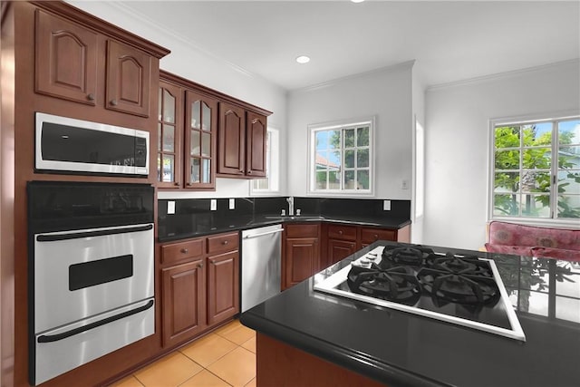 kitchen featuring a sink, appliances with stainless steel finishes, a warming drawer, and a healthy amount of sunlight