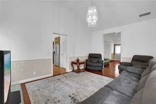 living area with wood finished floors, baseboards, a chandelier, and visible vents