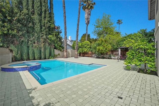 view of pool with a gazebo, a fenced backyard, a patio area, and a pool with connected hot tub