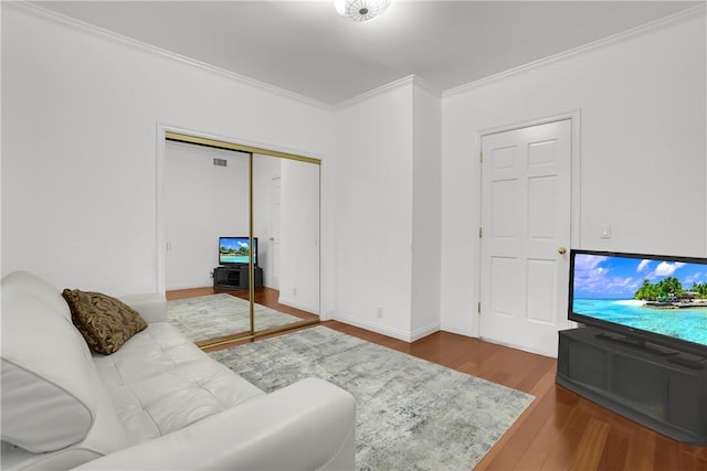 living area with crown molding and wood finished floors