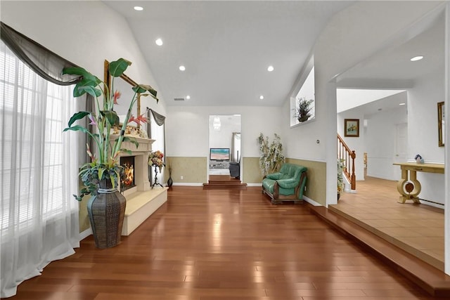 living area with stairs, recessed lighting, wood finished floors, and a fireplace