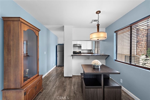 950 W Lambert Rd Unit 9, La Habra, CA 90631 - kitchen featuring dark countertops, freestanding refrigerator, white cabinetry, dark wood-type flooring, and visible vents