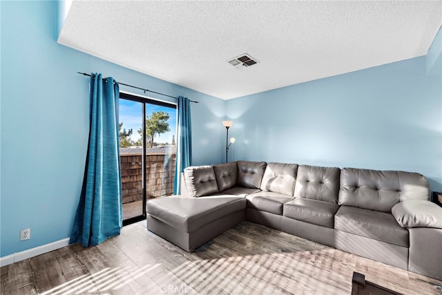 950 W Lambert Rd Unit 9, La Habra, CA 90631 - living room featuring a textured ceiling, baseboards, wood finished floors, and visible vents