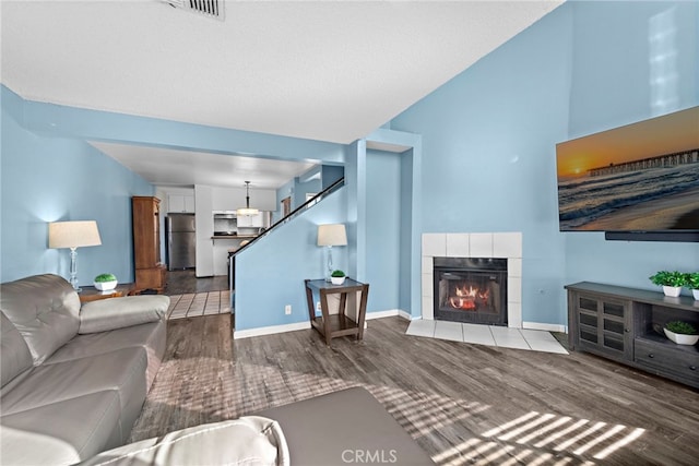 950 W Lambert Rd Unit 9, La Habra, CA 90631 - living area with a tiled fireplace, stairs, wood finished floors, and visible vents