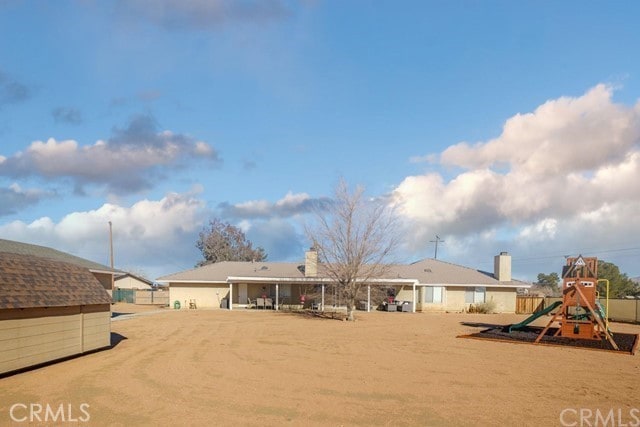rear view of property featuring playground community