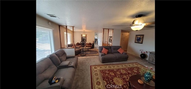 living room featuring ceiling fan, carpet flooring, a textured ceiling, and visible vents