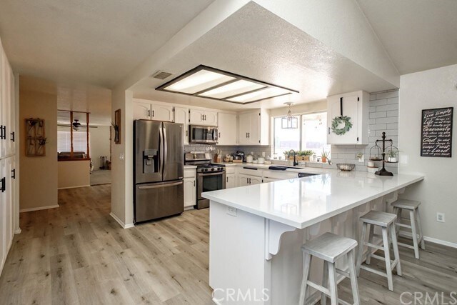 kitchen with a breakfast bar area, a peninsula, appliances with stainless steel finishes, and decorative backsplash