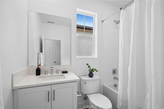 bathroom with visible vents, toilet, shower / tub combo, and vanity