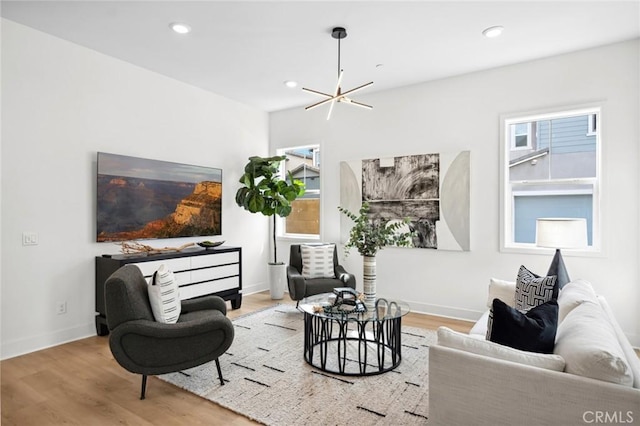 living area with recessed lighting, baseboards, a notable chandelier, and wood finished floors