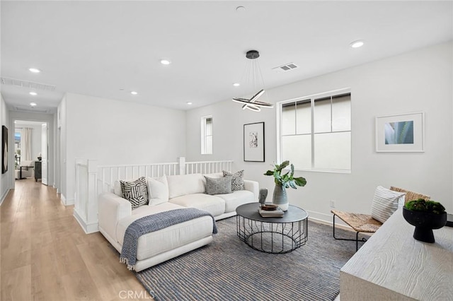 living area with light wood-style floors, baseboards, recessed lighting, and visible vents