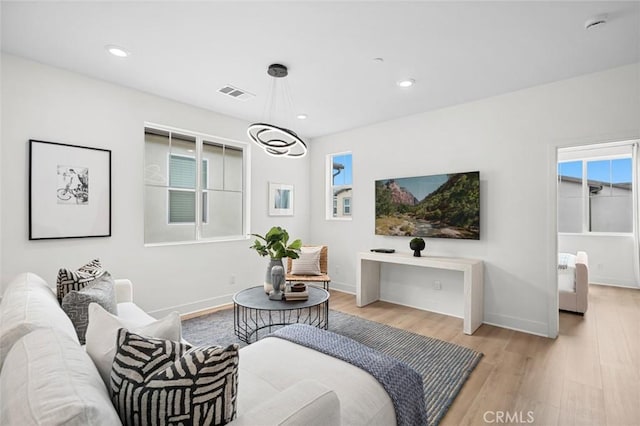 living area with recessed lighting, baseboards, and light wood-style flooring
