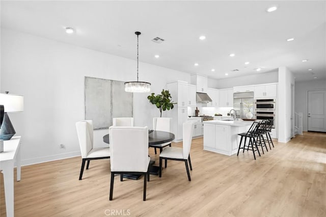 dining space with recessed lighting, baseboards, a chandelier, and light wood-type flooring