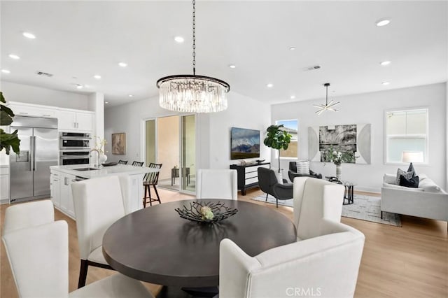 dining area featuring an inviting chandelier, recessed lighting, light wood-style floors, and visible vents