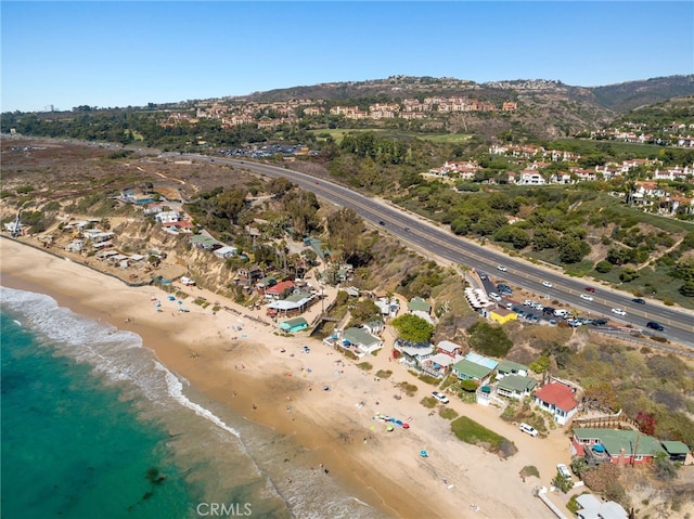 drone / aerial view with a residential view, a view of the beach, and a water and mountain view