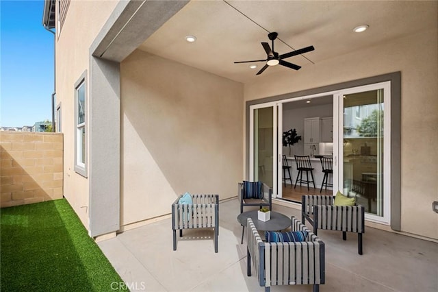 view of patio featuring fence, ceiling fan, and outdoor lounge area