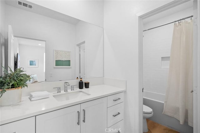 bathroom featuring visible vents, wood finished floors, vanity, toilet, and shower / bath combo with shower curtain
