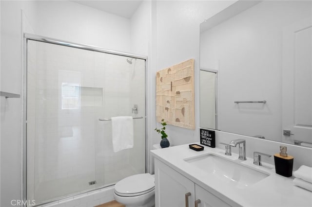 full bathroom featuring vanity, a stall shower, and toilet