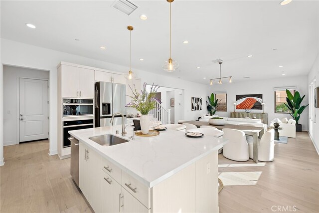 215 Sutters Ml, Irvine, CA 92602 - kitchen featuring a sink, stainless steel appliances, recessed lighting, light wood-type flooring, and visible vents