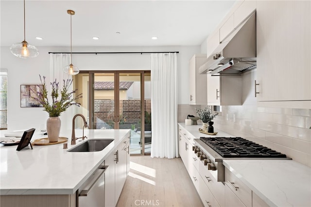 215 Sutters Ml, Irvine, CA 92602 - kitchen with a center island with sink, under cabinet range hood, a sink, light wood finished floors, and stainless steel appliances