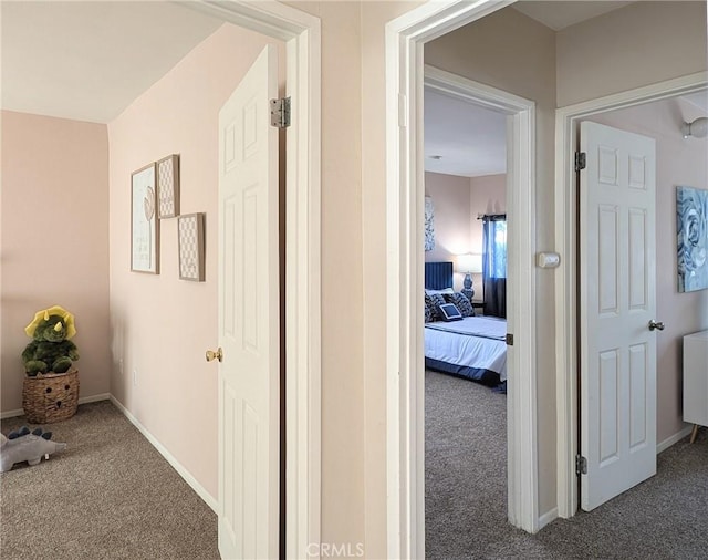 hallway with carpet flooring and baseboards