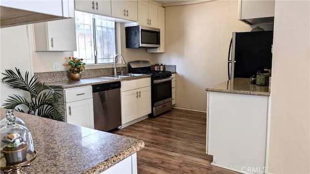 kitchen with a sink, white cabinets, stainless steel appliances, and dark wood-style floors