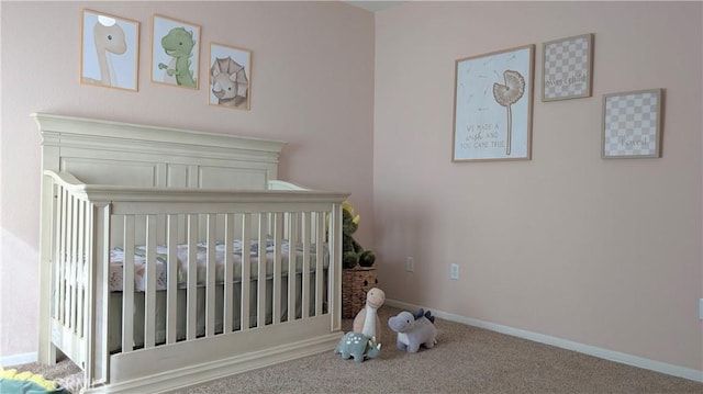 carpeted bedroom with a nursery area and baseboards