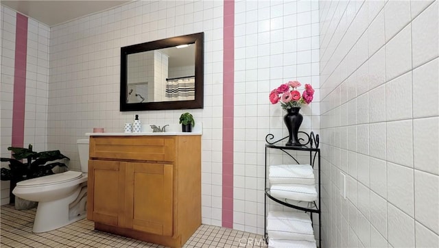 bathroom with tile walls, curtained shower, vanity, tile patterned floors, and toilet