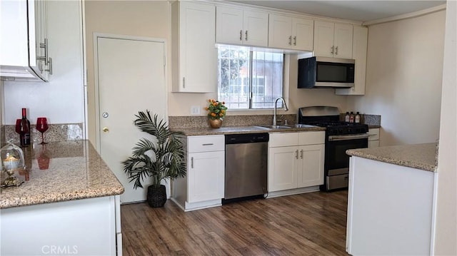 kitchen with white cabinets, stainless steel appliances, dark wood finished floors, and a sink