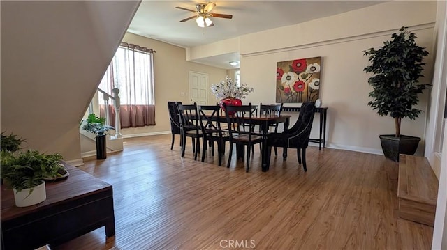 dining space with baseboards, light wood-style flooring, and ceiling fan