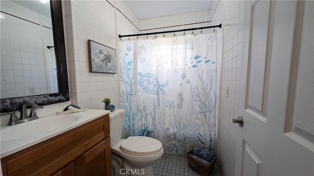 full bathroom with tile walls, tile patterned flooring, curtained shower, vanity, and toilet