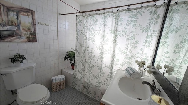 full bathroom featuring toilet, tile patterned floors, tile walls, and shower / bath combination with curtain
