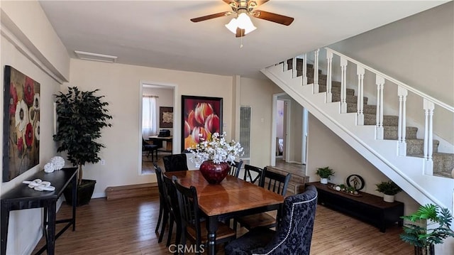 dining room with stairway, baseboards, ceiling fan, and wood finished floors