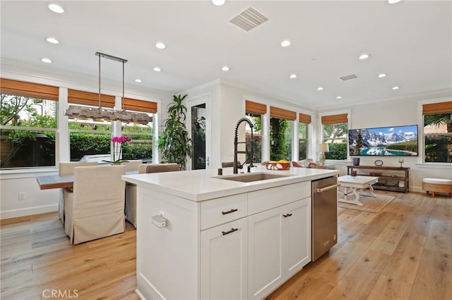 kitchen with a sink, ornamental molding, recessed lighting, and visible vents