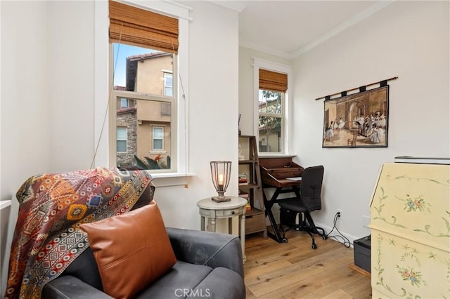 sitting room featuring ornamental molding and wood finished floors
