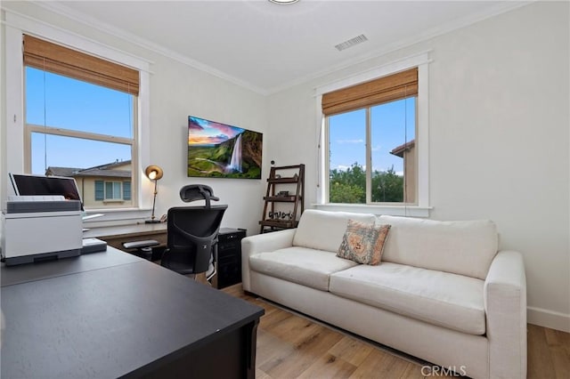 office space featuring baseboards, ornamental molding, wood finished floors, and visible vents