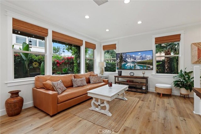 living room with visible vents, ornamental molding, light wood-style floors, baseboards, and recessed lighting