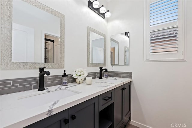 bathroom featuring a sink, baseboards, and double vanity