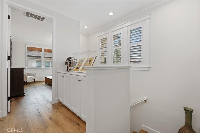 hall with crown molding, recessed lighting, an upstairs landing, light wood-type flooring, and visible vents