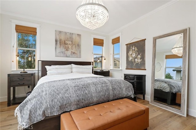 bedroom with an inviting chandelier, light wood-style floors, crown molding, and multiple windows