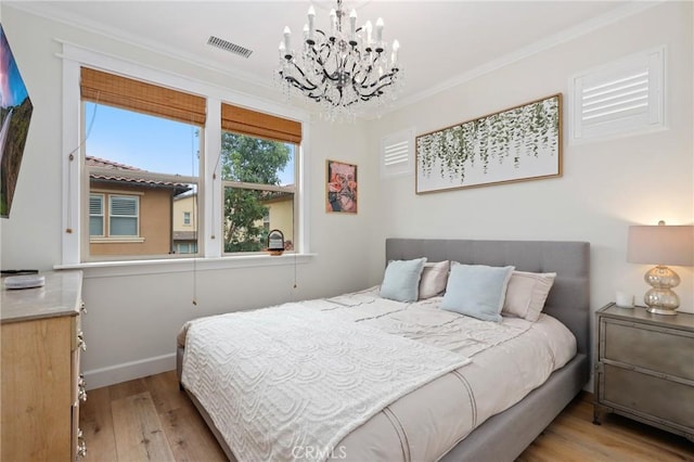 bedroom with visible vents, wood finished floors, baseboards, a chandelier, and ornamental molding