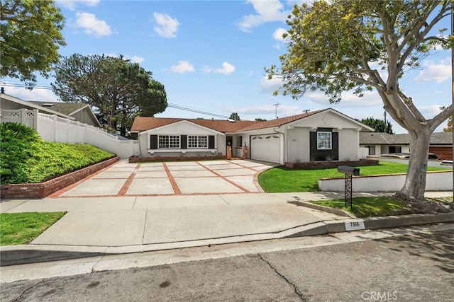 ranch-style home featuring a garage, fence, a front yard, stucco siding, and concrete driveway