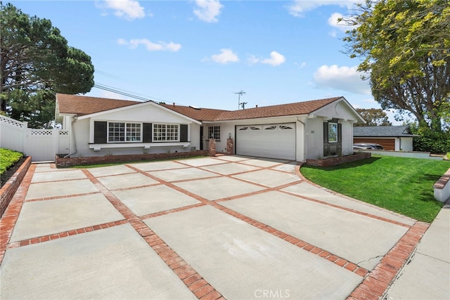 view of front facade with driveway, fence, a front lawn, an attached garage, and stucco siding