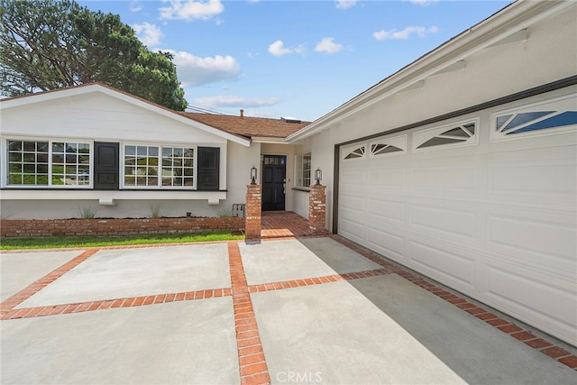 ranch-style home featuring a garage, stucco siding, and concrete driveway