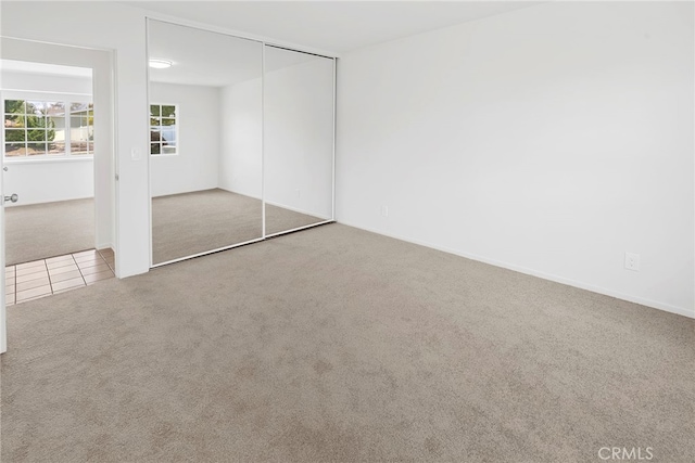 unfurnished bedroom featuring carpet floors and a closet