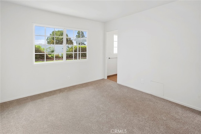 empty room featuring baseboards and carpet