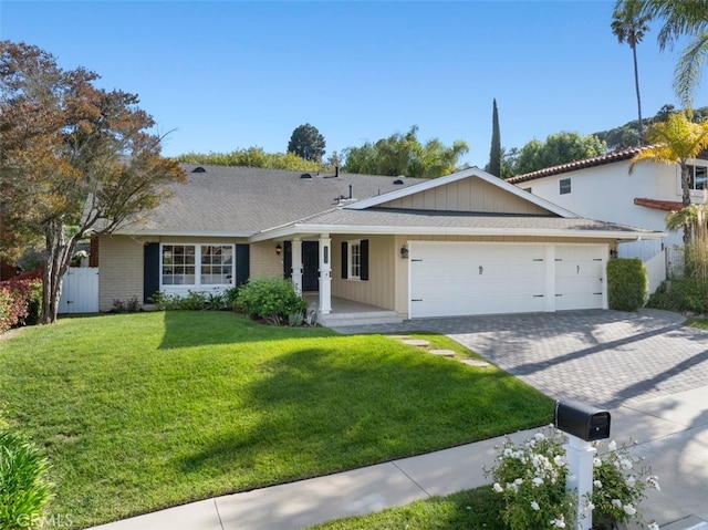 ranch-style house with fence, a garage, a porch, a front yard, and decorative driveway